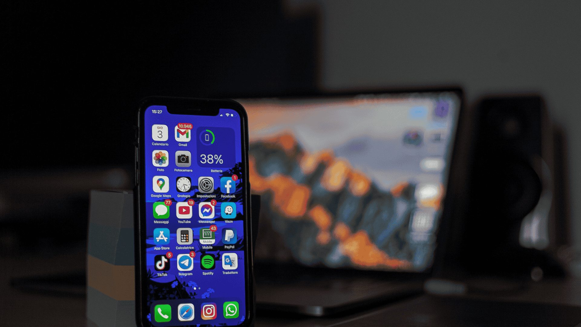 Smartphone posé sur un bureau devant un ordinateur portable, illustrant l’usage d’une application de gestion locative.