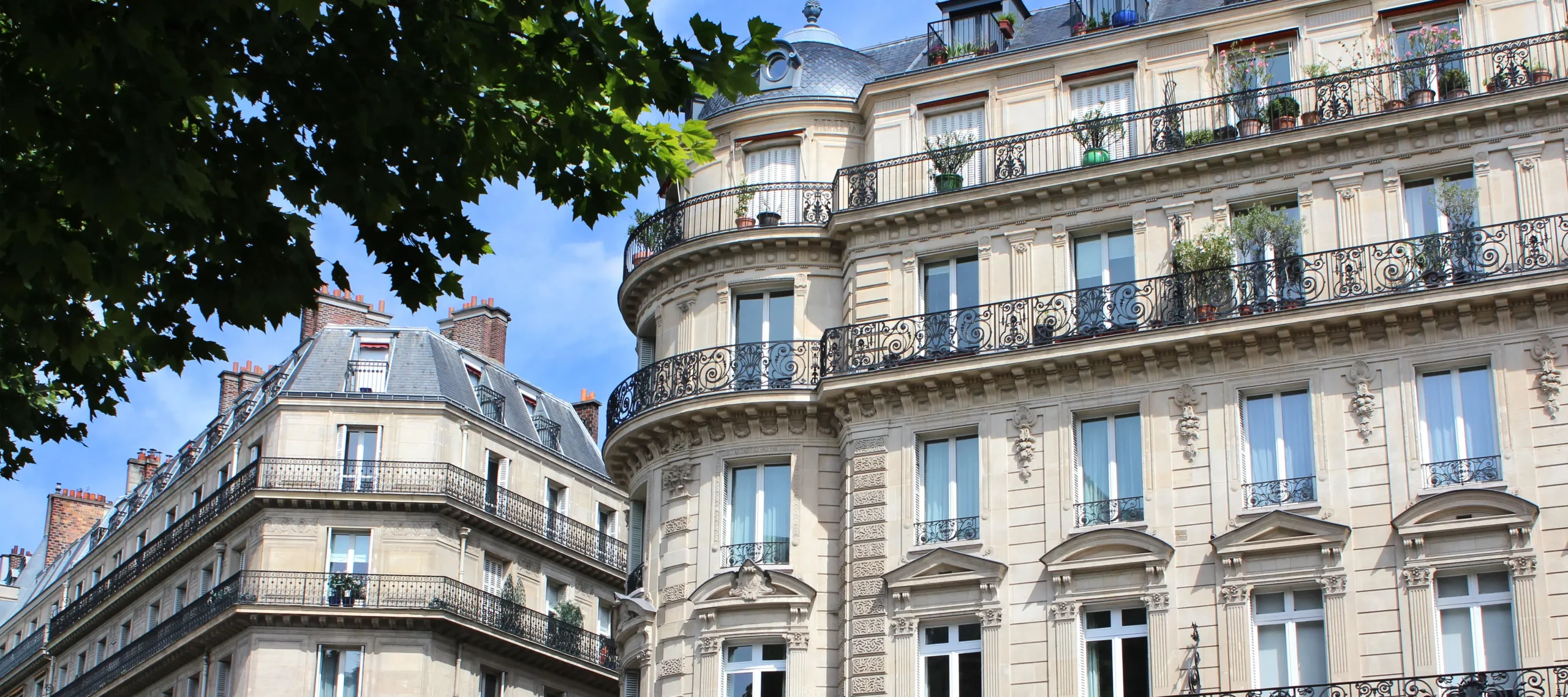 Façade d’un immeuble résidentiel en ville, avec balcons et fenêtres, vue en contre-plongée.