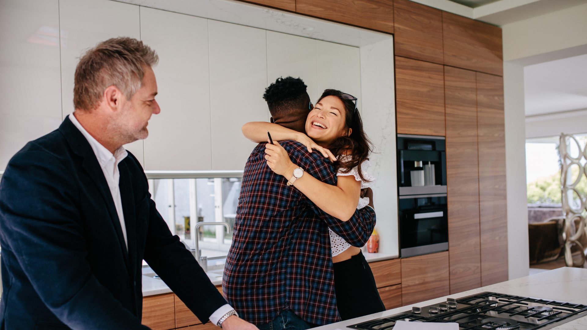 Propriétaire visitant un logement avec un couple, dans le cadre du suivi d’un bien en SCI ou en gestion locative.